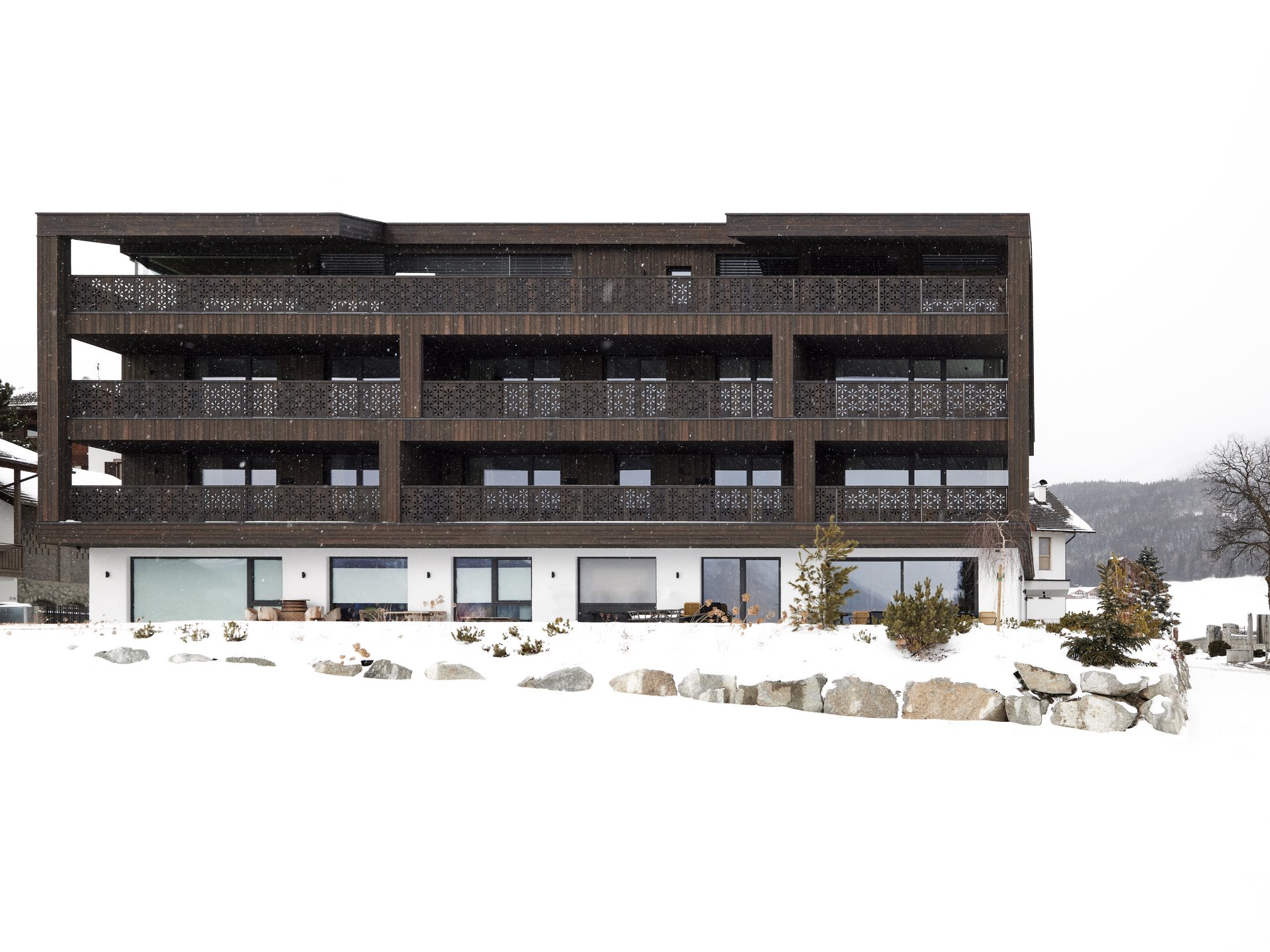 Urlaub in Südtirol: Auf in die Mountain Lodge Margit! ❋ Modernes Chalet mit dunklem Holz und Balkon im verschneiten Winter